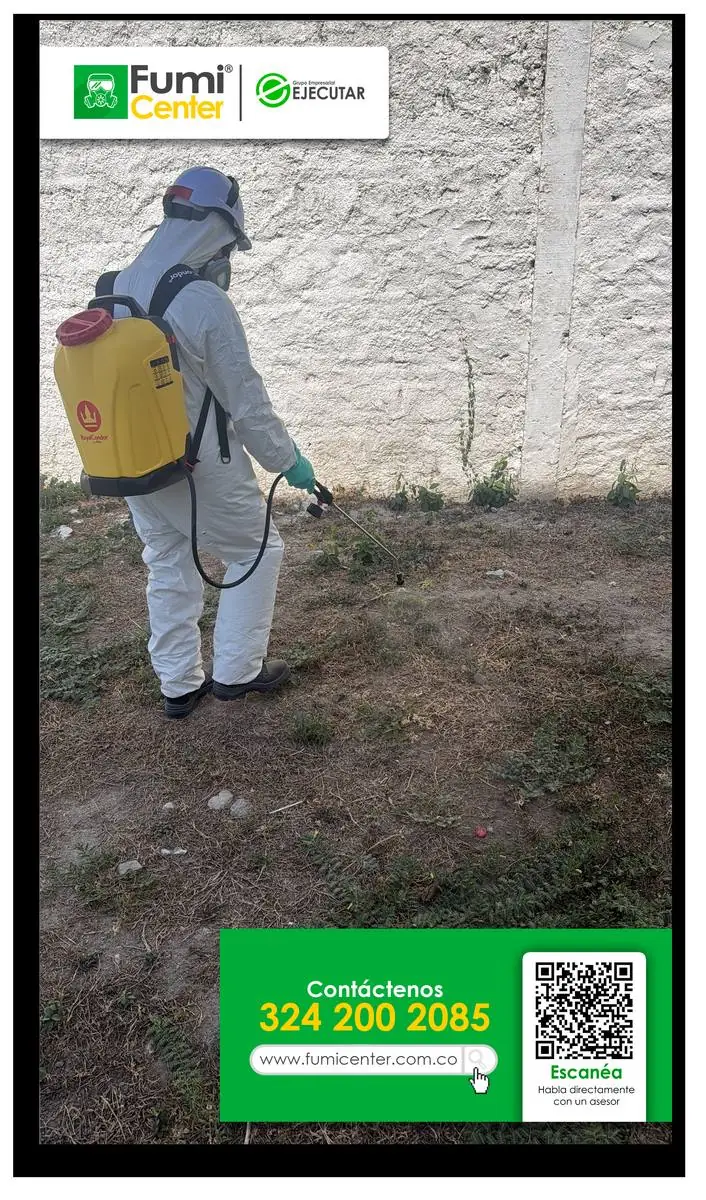 Técnico de FumiCenter aplicando en la base de un muro exterior