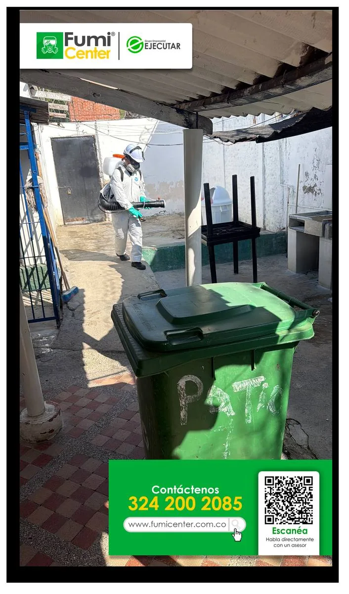 Técnico de FumiCenter aplicando en un patio junto a una caneca de basura