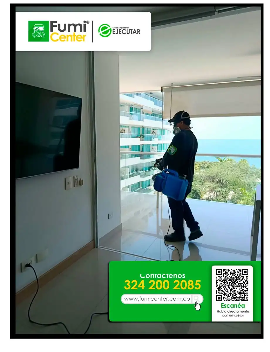 Técnico de FumiCenter aplicando en la sala de un apartamento con vista al mar