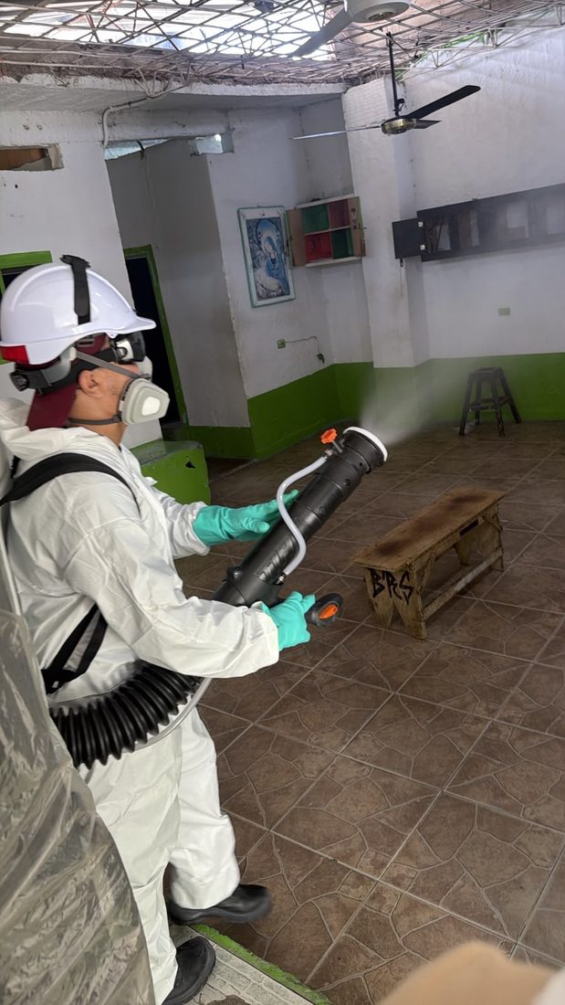 Técnico de FumiCenter con termonebulizador en una bodega